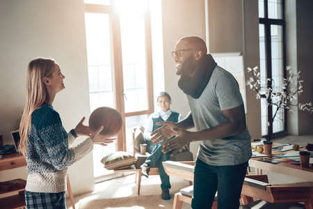 Multinational company plays basketball in office.の写真素材