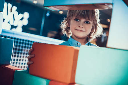 Little boy smiles while standing in attraction.の写真素材