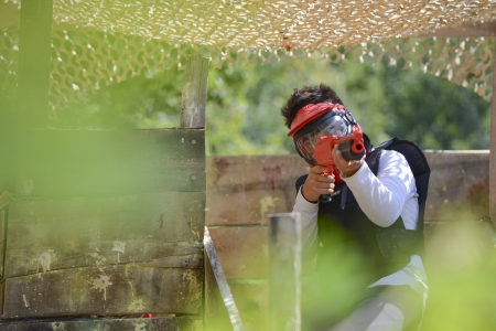 Young children playing paintball in the woodsの写真素材