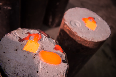 Foundry worker pouring hot metal into castの写真素材