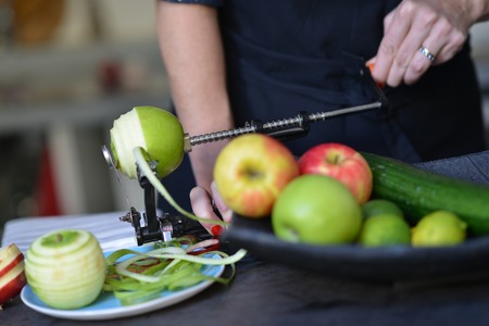 Chef Peel green apple with machine in kitchenの写真素材