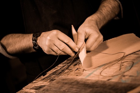 leather goods craftsman at work in his workshop, France