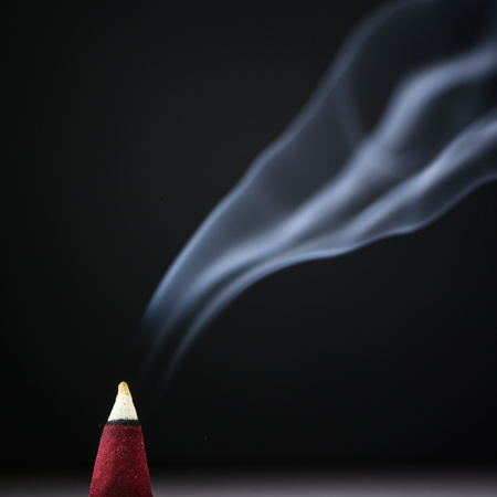 Incense stick with smoke on  black backgroundの写真素材