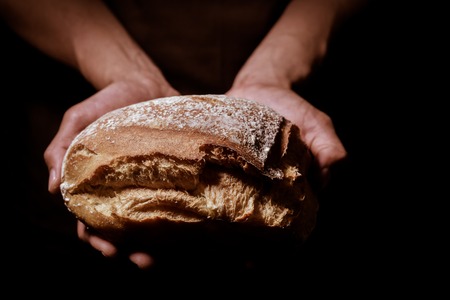 Baker man holding a beautiful round breadの写真素材