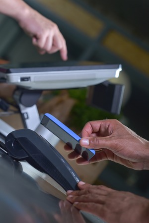 Payment in a trade with nfc system with mobile phone in supermarket.の写真素材