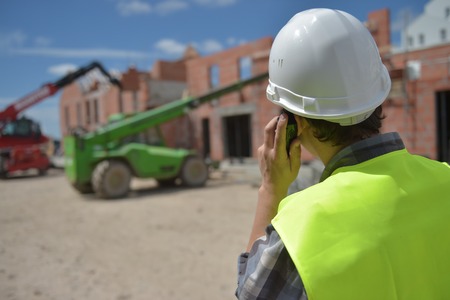 Foreman using walkie-talkie on construction site, Franceの写真素材