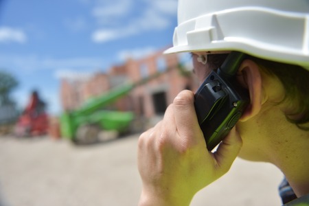 Foreman using walkie-talkie on construction site, Franceの写真素材