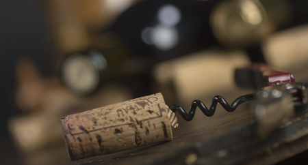 Opening a wine bottle with corkscrew, white background, Winery