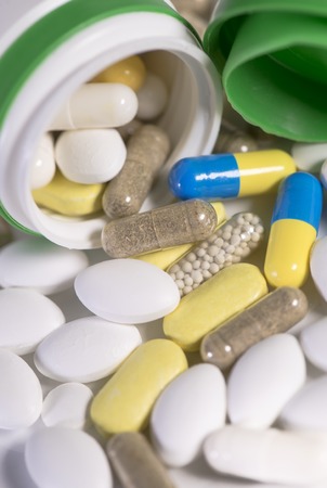 Colored pills, tablets and capsules on a white backgroundの写真素材