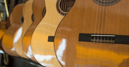 Many Classical Guitars Hanging on Wall in the Shopの写真素材