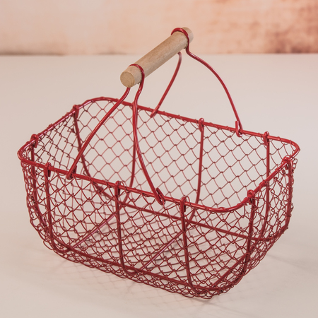 Red wire basket for seashells on white backgroundの写真素材