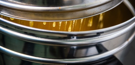 Strain the poured honey through a sieve. How to Harvest Honey. Filtering raw honey, Franceの写真素材