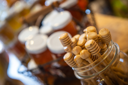 Jars and honey sticks with natural honey on shelf in shop. Sale of natural honey in market. Production of honey, Franceの写真素材