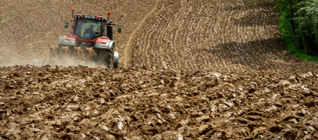 Farmer on tractor plow field, France, Europe