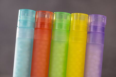 Modern Color homeopathic pills in plastic container on black background, France