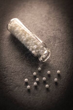Modern Color homeopathic pills in plastic container on black background, Franceの写真素材