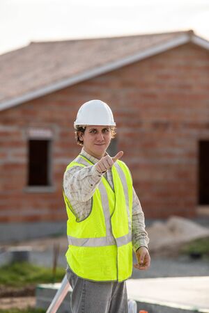 Professional engineer architect worker with protective helmet at house building construction site...