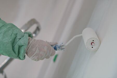 Roller painting white wall, ceiling with white paintの写真素材