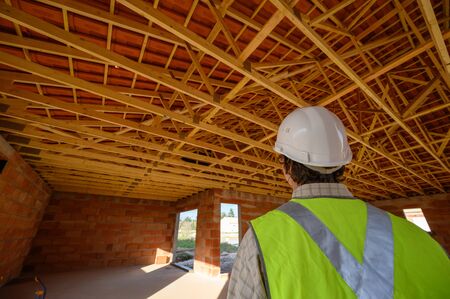 Professional engineer architect worker with protective helmet at house building construction site...