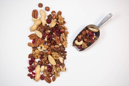 Mixed nuts and dried fruits in wooden bowl on white background, copy space