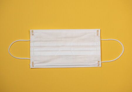 Protective medical equipment during a virus epidemic, Surgical mask on yellow background