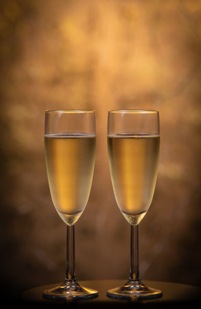 Champagne glasses over holiday bokeh blinking background, glasses with sparkling wine, celebration, partyの写真素材