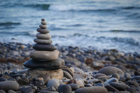 Stone piles made along a beach and the sea in the background