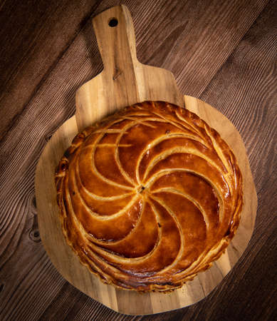 Galette des rois on wooden table, Traditional Epiphany cake in France