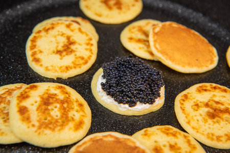 Blinis with black caviar and cream cheese, on a festive dish, mini pancakes, an elegant appetizerの写真素材