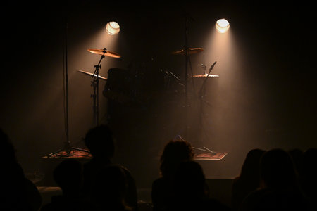 Exciting live concert atmosphere with dramatic lighting and eager audience anticipationの写真素材