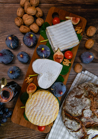 Selection of French cheeses from Normandy, Livarot, Neufchatel, Pont leveque, Rye bread, figs, walnuts, grapes, elderberry geleeの写真素材