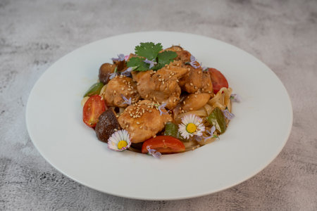 Delicious chicken, linguine, shiitake mushrooms, and garden flowers pasta dish for a delightful dining experienceの写真素材