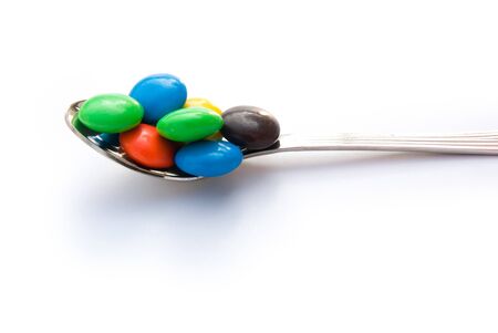 colorful chocolate buttons on spoonの写真素材