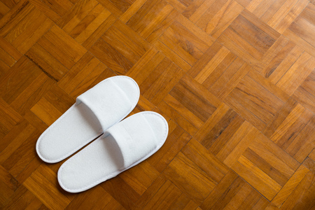 pair of white slippers on a wooden floorの写真素材