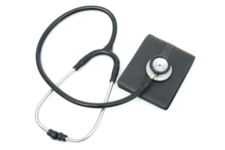 stethoscope above a wallet on white backgroundの写真素材