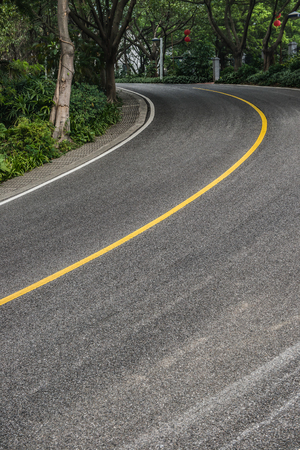 curved road with trees on both sidesの写真素材