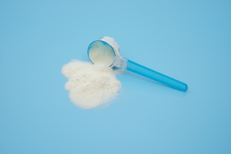 powdered milk in a blue spoon on blueの写真素材