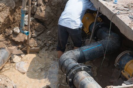 man fixing drainage pipe の写真素材