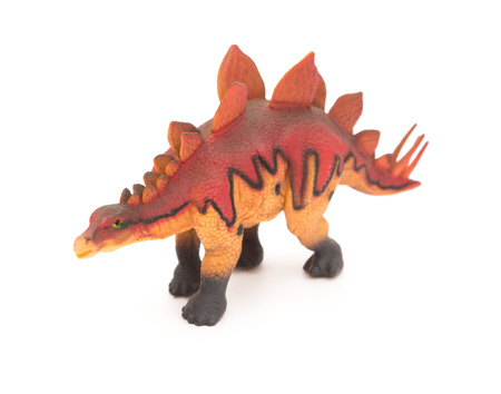 side view red stegosaurus toy on a white backgroundの写真素材