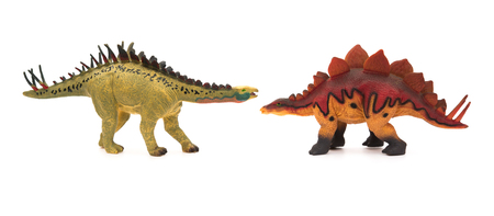 yellow huayangosaurus  and red stegosaurus toys on a white backgroundの写真素材