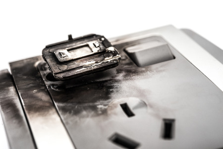 burnt out electric socket stuck with a broken plugの写真素材