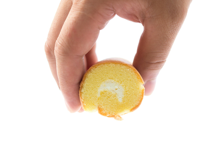 hand holding a piece of cake with cream in middle on whiteの写真素材