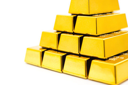 pieces of gold bars stacked up on a white backgroundの写真素材
