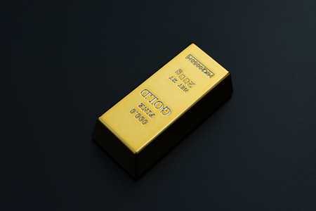 piece of gold bar on a black backgroundの写真素材