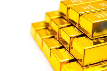pieces of gold bars stacked up on a white backgroundの写真素材