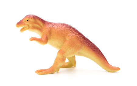 side view orange plastic dinosaur toy on a white backgroundの写真素材