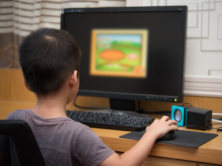 kid playing a computer game for children at homeの写真素材