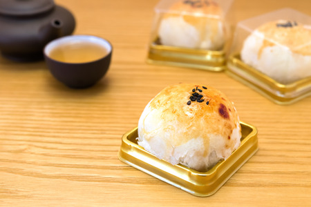 traditional chinese snack of preserved egg cakes with tea on a wood tableの写真素材
