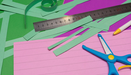 ruler and scissors and hand cut paper straps on colorful scrapbookの写真素材
