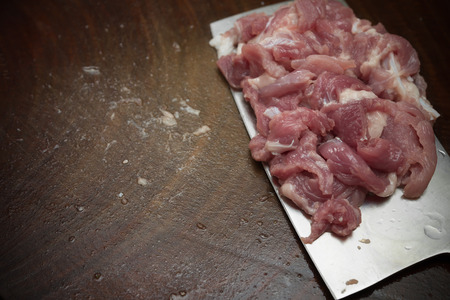 slicing raw pork on a wooden chopboardの写真素材